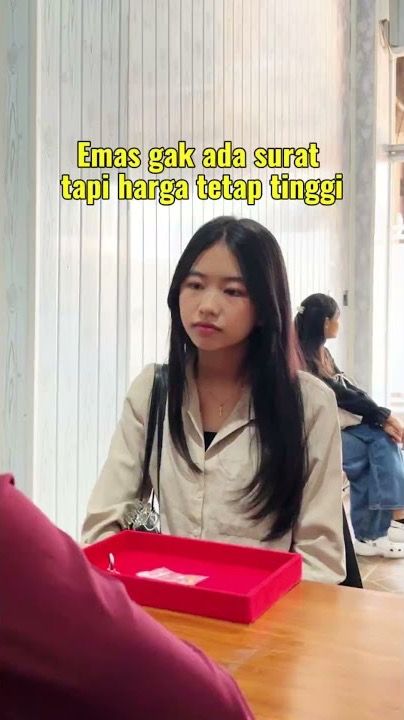 Pelanggan duduk di meja toko Junifa Gold dengan baki merah berisi perhiasan, bertuliskan Emas gak ada surat tapi harga tetap tinggi